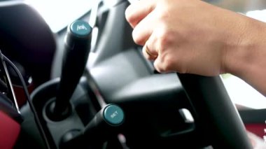 Kadın ellerini direksiyona yaklaştırın ve araba sürerken uyarlanabilir Cruise Control düğmesine basın. Ulaşım Konsepti.