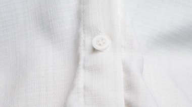 Kadın elinin kapağı beyaz gömleğin düğmesini çözüyor. Sıcaklık kavramı.