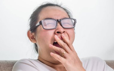 Evdeki kanepede oturan esneyen kadın..