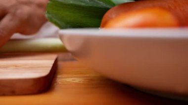 Japon Uzun Soğanı, Japon Scallion 'u ya da tahta kesme tahtasındaki Yeşil Soğan' ı kesmek için mutfak bıçağı kullanan bir kadın. Kadın mutfakta yemek hazırlıyor. Yemek pişirme konsepti.