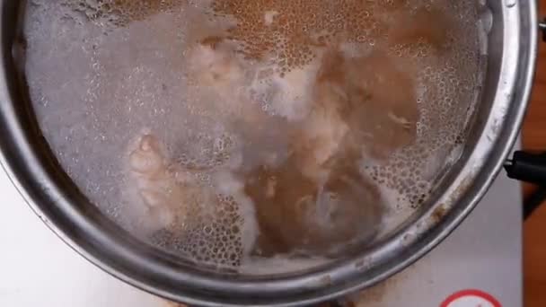 キッチンの電気ストーブの上の鍋に豚カルビでスープをゆでた 料理のコンセプト — ストック動画