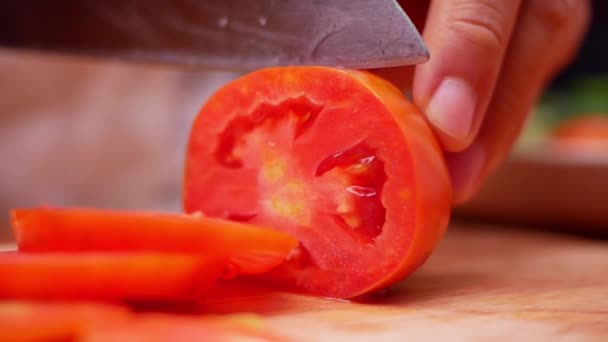 女手用菜刀在木制切菜板上切成熟的西红柿 女人正在厨房准备家里的食物 烹调概念 — 图库视频影像