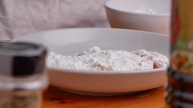 Eldiven takan bir kadın, tavuk parçalarını evde lezzetli kızarmış tavuk yapmak için soya sosu ve unla marine ediyor. Yemek pişirme konsepti.