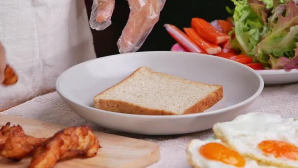 Frau Handschuhen Kocht Vollkornbrot Sandwich Mit Gebratenem Huhn Salat Tomaten — Stockvideo