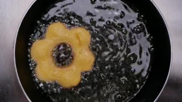キッチンストーブの上の鍋に熱い油でおいしいと自家製のドーナツを飛んでいます 調理プロセス — ストック動画