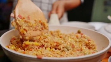 Kadın sebzeli ev yapımı pilav ve Tayland soslu taze soğan pişiriyor. Mutfak ocağında tavada. Sağlıklı yemek hazırlama kavramı.