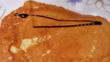 Kahvaltı için tabağında çikolata sosu olan leziz krepleri kapatıyoruz. Ev yapımı krep..