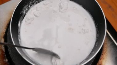 Tayland tatlıları için hazırlanan tavada hindistan cevizi sütünü yavaşça karıştır..