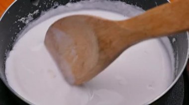 Tayland tatlıları için hazırlanan tavada hindistan cevizi sütünü yavaşça karıştır..