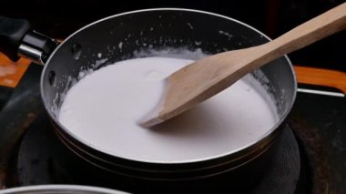 Tayland tatlıları için hazırlanan tavada hindistan cevizi sütünü yavaşça karıştır..