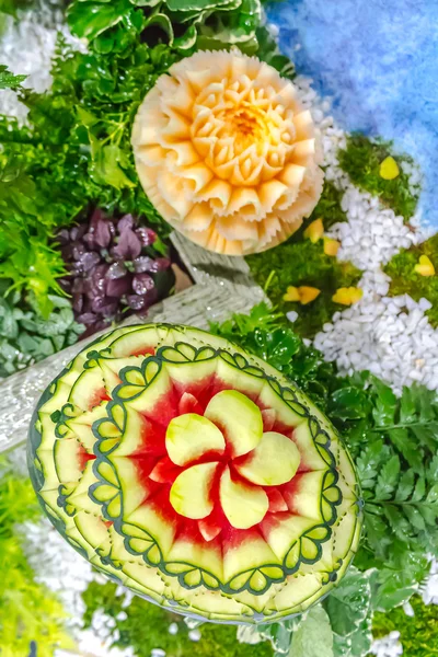 Cantaloup et pastèque sculptant dans le jardin sur table s — Photo