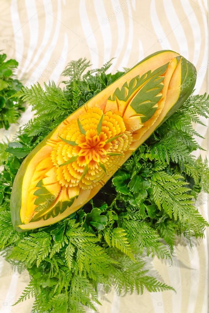 Papaya fruit carving in the form of flower and fern leaves.