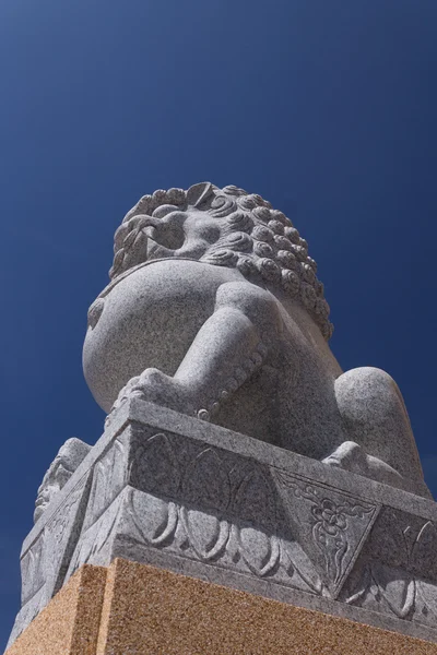 Aslan heykeli mavi göl kenarında üzerinde — Stok fotoğraf