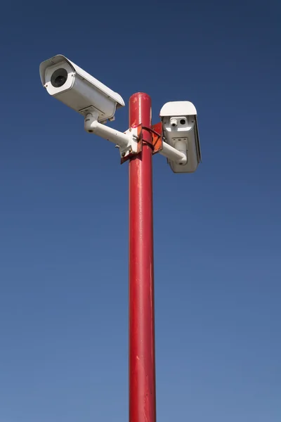 Überwachungskamera auf roter Säule, blau isoliert — Stockfoto