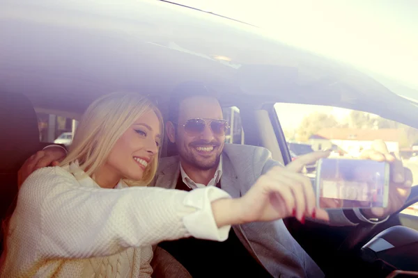 Jovem casal tirando uma selfie no carro — Fotografia de Stock