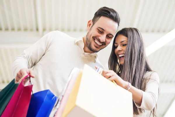 Pareja mirando sus bolsas de la compra —  Fotos de Stock