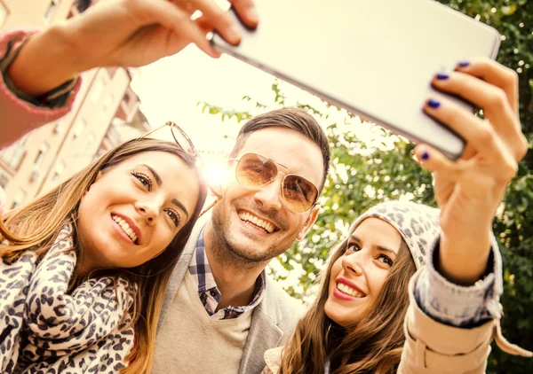 Unga människor skrattar och gör en selfie — Stockfoto