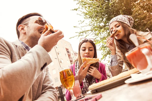 Joven grupo de personas riendo comiendo pizza y divirtiéndose —  Fotos de Stock