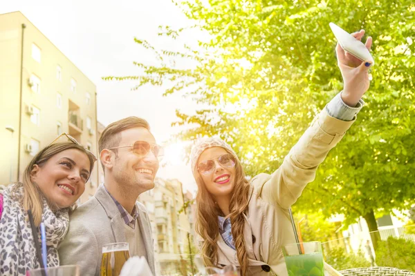 Grupo de jóvenes riendo y haciendo una selfie — Foto de Stock