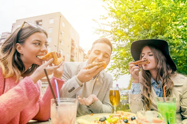 Glada människor äta pizza och dricka öl utomhus — Stockfoto