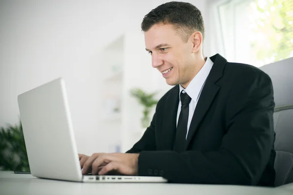 Empresário trabalhando em seu laptop no escritório — Fotografia de Stock