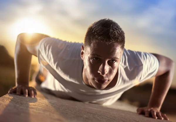 Jonge atletische man doet push-ups buiten — Stockfoto