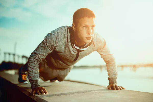 Resim gönderme yapan bir genç atletik erkek açık havada ups — Stok fotoğraf