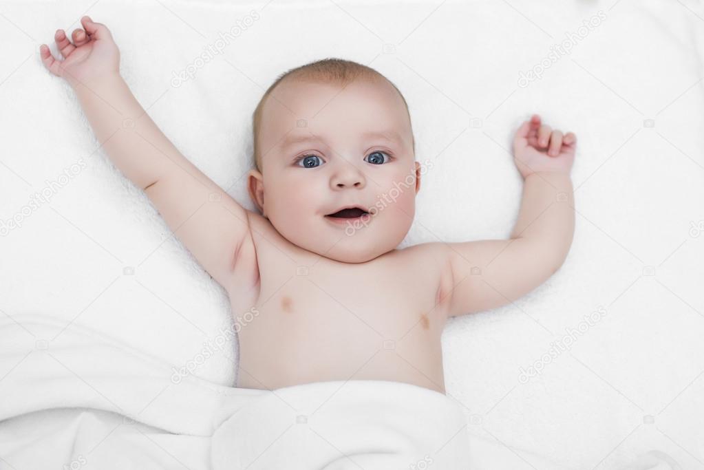 Baby boy playing on his bed