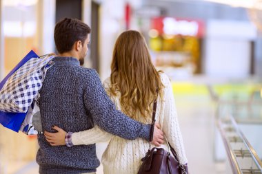 mutlu genç bir çift ile alışveriş torbaları