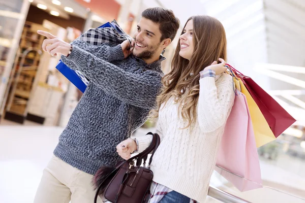 Pareja joven feliz con bolsas de compras —  Fotos de Stock