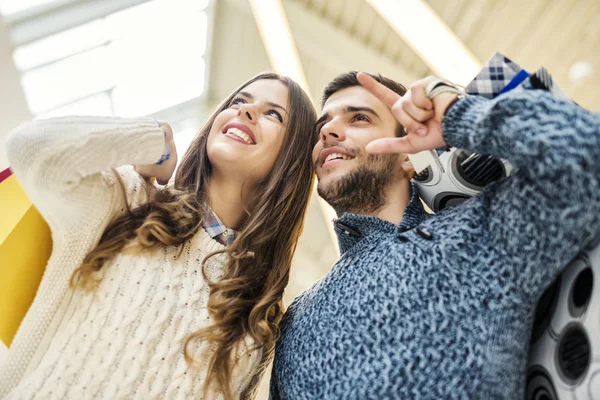 Pareja joven feliz con bolsas de compras — Foto de Stock