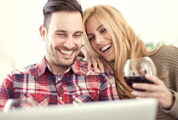 Genç bir çift evde kırmızı şarap ile kutluyor — Stok fotoğraf