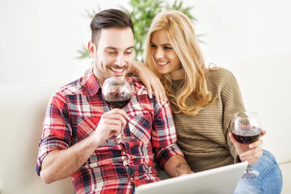 Genç bir çift evde kırmızı şarap ile kutluyor — Stok fotoğraf