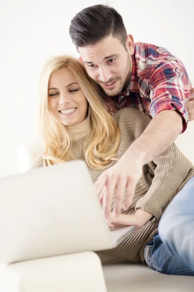 Evde, dizüstü bilgisayar kullanarak ve gülümseyen tarama internet genç Çift — Stok fotoğraf