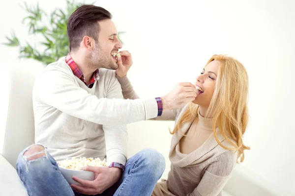 Pareja alegre comiendo palomitas de maíz — Foto de Stock