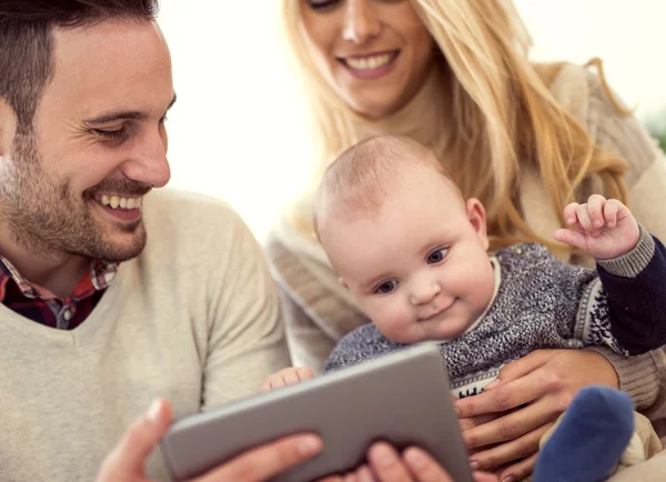 Pareja jugando con el bebé y utilizando la tableta digital — Foto de Stock