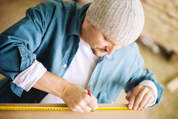 Tischler arbeitet in seiner Werkstatt an einem Holzbrett — Stockfoto