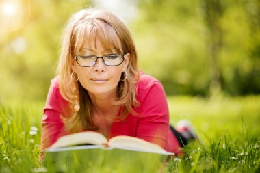 Mutlu kadın doğa ilkbaharda sırasında bir kitap okuma