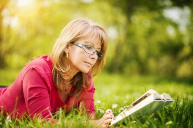 Parkta kitap okuyan kadın.