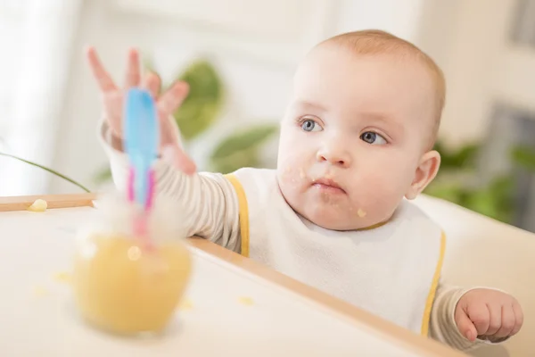 Baby eten in zijn kinderstoel — Stockfoto