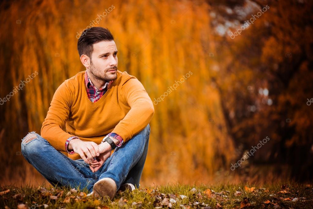 Stylish smiling male sitting in the park - a Royalty Free Stock Photo from  Photocase