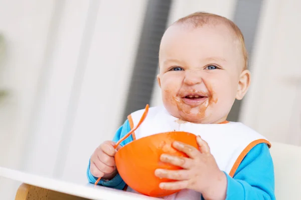 Barn äter. Baby pojke i barnstol utfodring själv . — Stockfoto