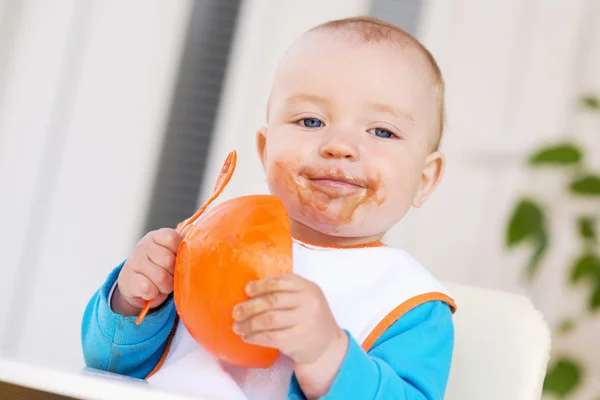 Nourriture pour bébés. Bébé garçon dans une chaise haute se nourrissant  . — Photo