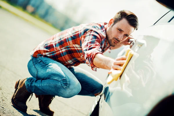 Ο νεαρός καθαρίζει το αμάξι του έξω. — Φωτογραφία Αρχείου