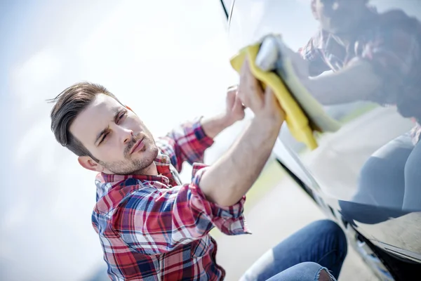 Mladý muž čistí své auto venku — Stock fotografie