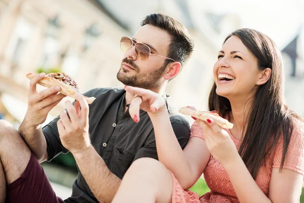 Unga par äter pizza — Stockfoto