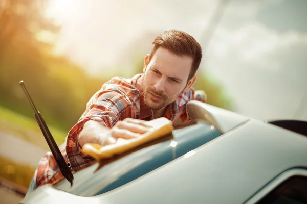 Молодой человек чистит свою машину — стоковое фото