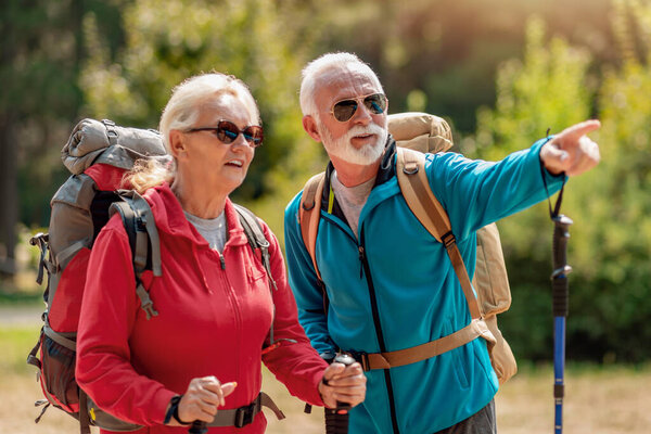 Senior couple with backpacks on hiking enjoy in nature. Love, people, nature and lifestyle concept.