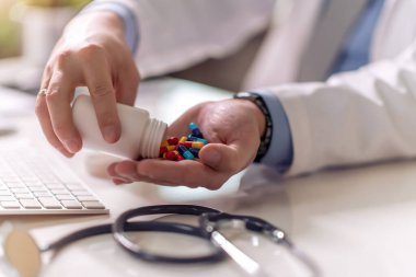 Doktor elinde haplar gösteriyor. Sağlık, tıbbi ve eczane konsepti.