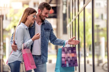 Şehirde alışveriş torbaları olan bir çiftin portresi..